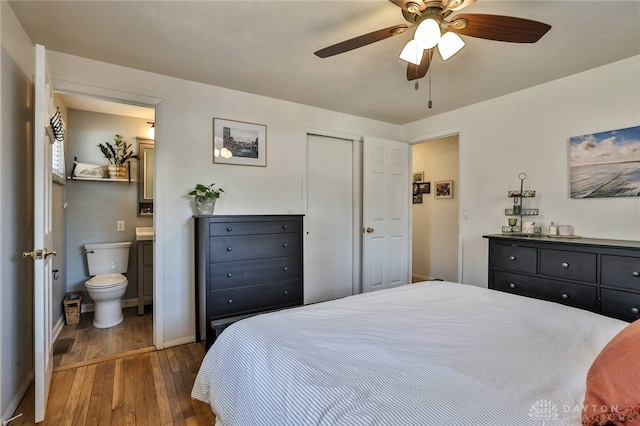 bedroom featuring ceiling fan, baseboards, wood finished floors, and ensuite bathroom