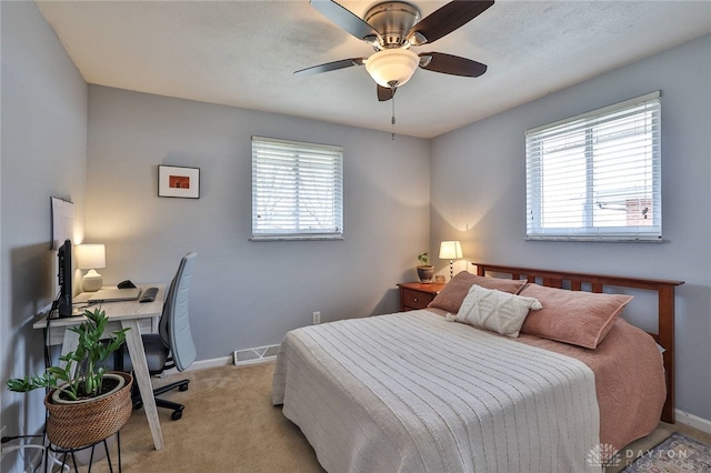 bedroom featuring multiple windows, light colored carpet, visible vents, and baseboards