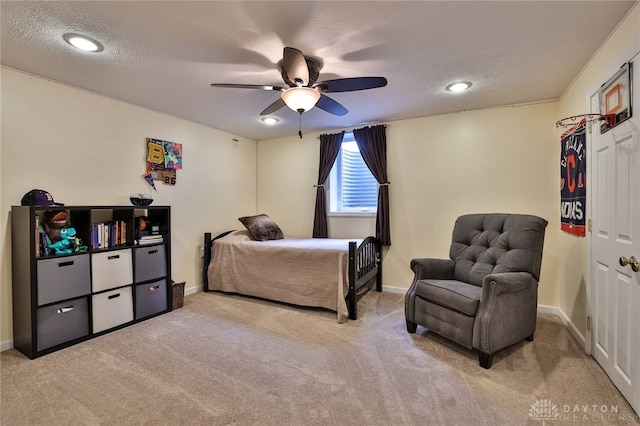 bedroom with light carpet, ceiling fan, a textured ceiling, and baseboards