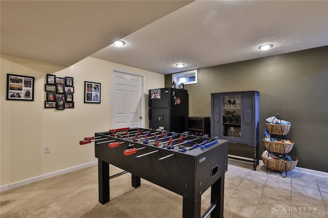 rec room featuring baseboards and a textured ceiling