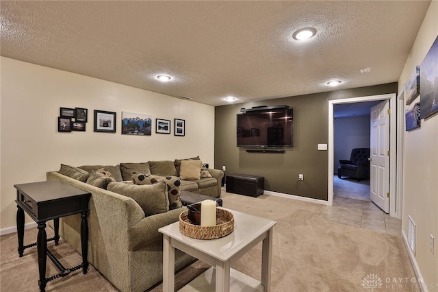 living room featuring a textured ceiling, baseboards, visible vents, and light carpet