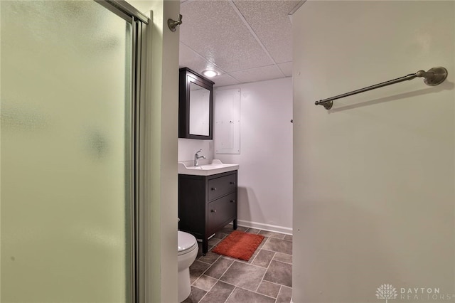 full bathroom featuring vanity, toilet, a paneled ceiling, and a stall shower