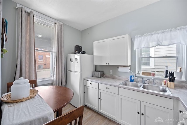 131 S Mulberry St, Troy, OH 45373 - kitchen featuring freestanding refrigerator, white cabinetry, light countertops, and light wood-style flooring