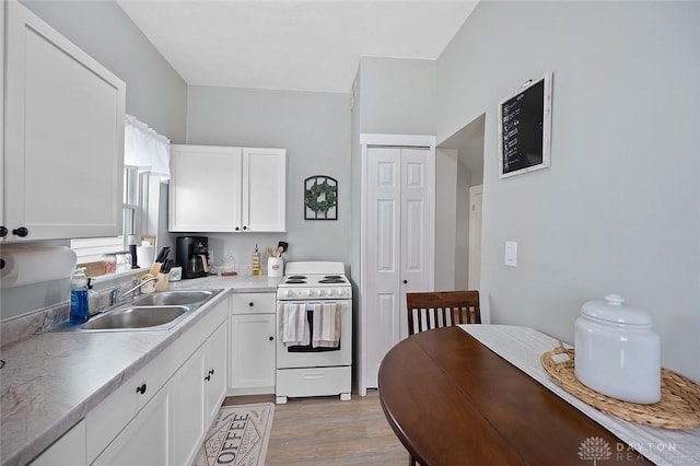 131 S Mulberry St, Troy, OH 45373 - kitchen featuring white electric range, white cabinetry, light wood-style flooring, and light countertops