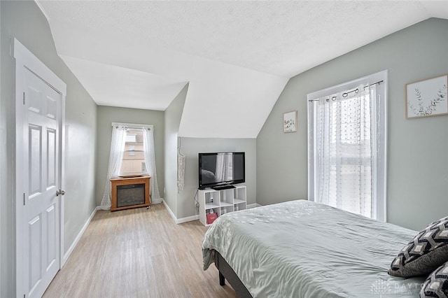 131 S Mulberry St, Troy, OH 45373 - bedroom with light wood-style flooring, vaulted ceiling, and a textured ceiling