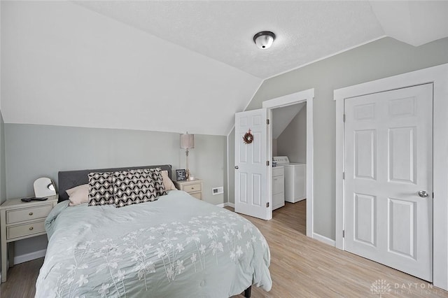 131 S Mulberry St, Troy, OH 45373 - bedroom featuring vaulted ceiling, light wood-style floors, separate washer and dryer, and a textured ceiling
