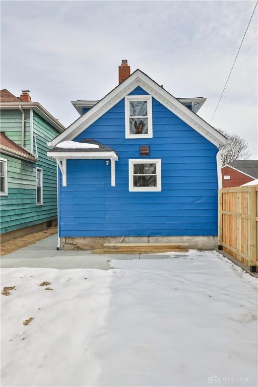 rear view of house with fence and a chimney