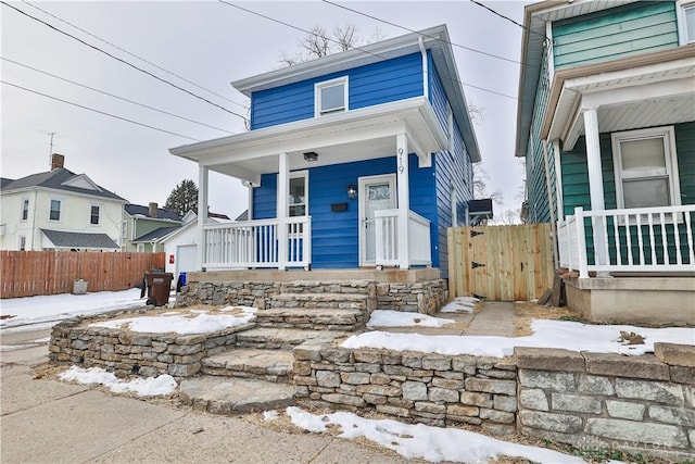 view of front of property with a porch and fence