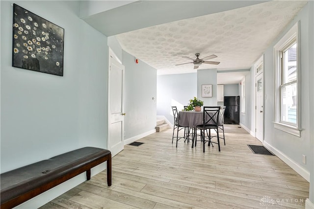 dining space featuring plenty of natural light, light wood finished floors, and baseboards