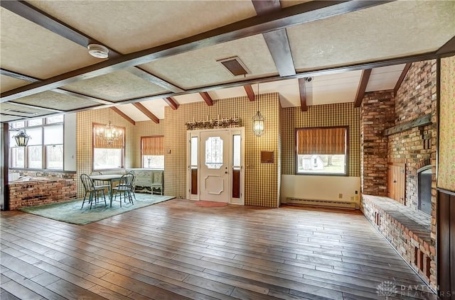 1831 Fairfield Pike, Springfield, OH 45502 - entrance foyer with hardwood / wood-style floors, visible vents, brick wall, an inviting chandelier, and a baseboard heating unit