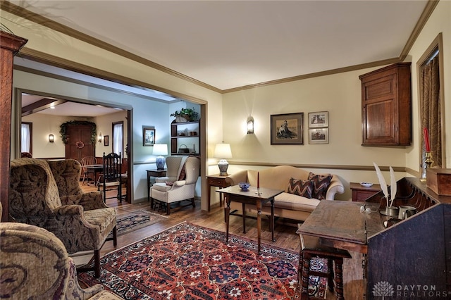 living room with wood finished floors and crown molding