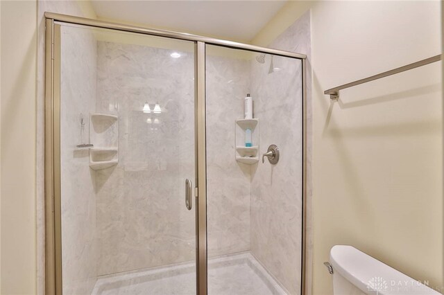 bathroom with toilet and a stall shower