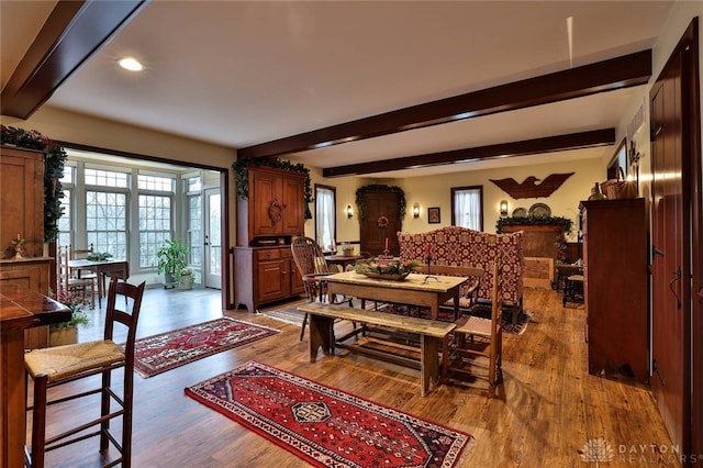 dining area with beam ceiling, recessed lighting, and wood finished floors