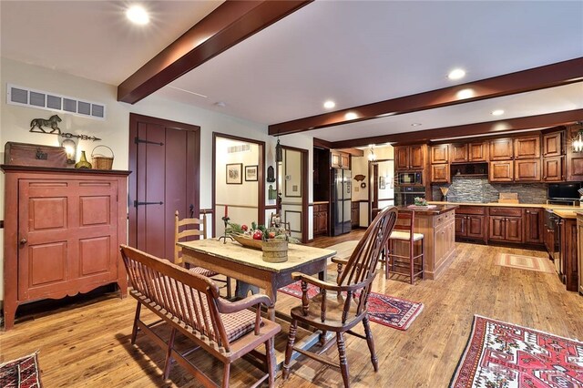 dining space with beam ceiling, visible vents, light wood-type flooring, and recessed lighting