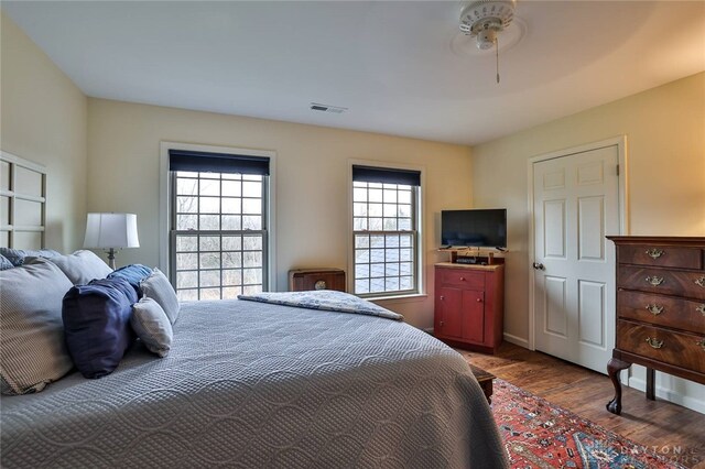 bedroom featuring wood finished floors, visible vents, and baseboards
