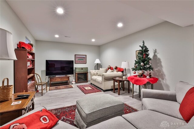 living room featuring light wood finished floors, recessed lighting, and visible vents
