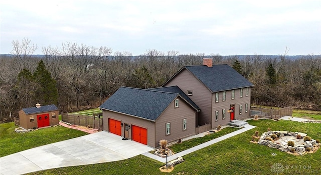 exterior space with a lawn, a chimney, a shingled roof, and a view of trees