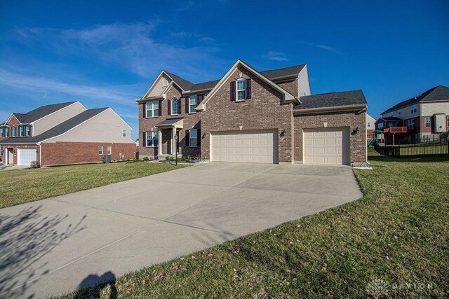 view of front of home featuring a front yard, an attached garage, brick siding, and driveway