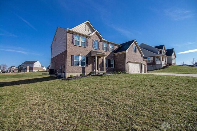 traditional-style home featuring brick siding, a residential view, a front yard, and a garage