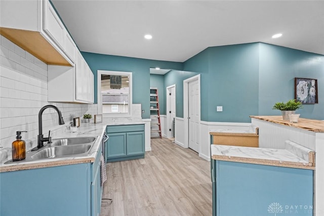 1546 W 1st St, Dayton, OH 45402 - kitchen featuring blue cabinetry, light countertops, light wood finished floors, a wainscoted wall, and recessed lighting