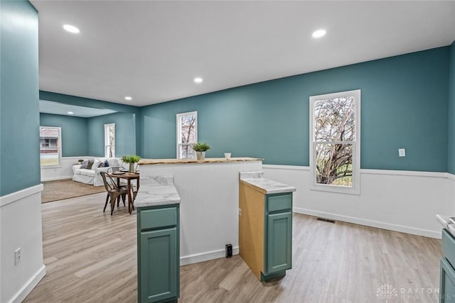 1546 W 1st St, Dayton, OH 45402 - kitchen featuring green cabinets, light wood-style flooring, light countertops, recessed lighting, and open floor plan
