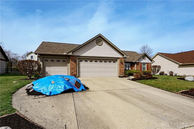 ranch-style home with brick siding, an attached garage, concrete driveway, and a front yard