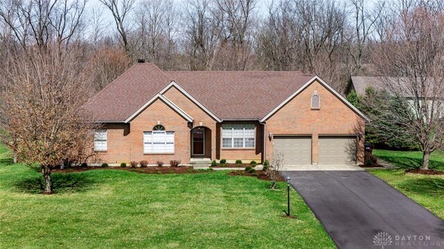 ranch-style home featuring brick siding, a front lawn, aphalt driveway, roof with shingles, and a garage