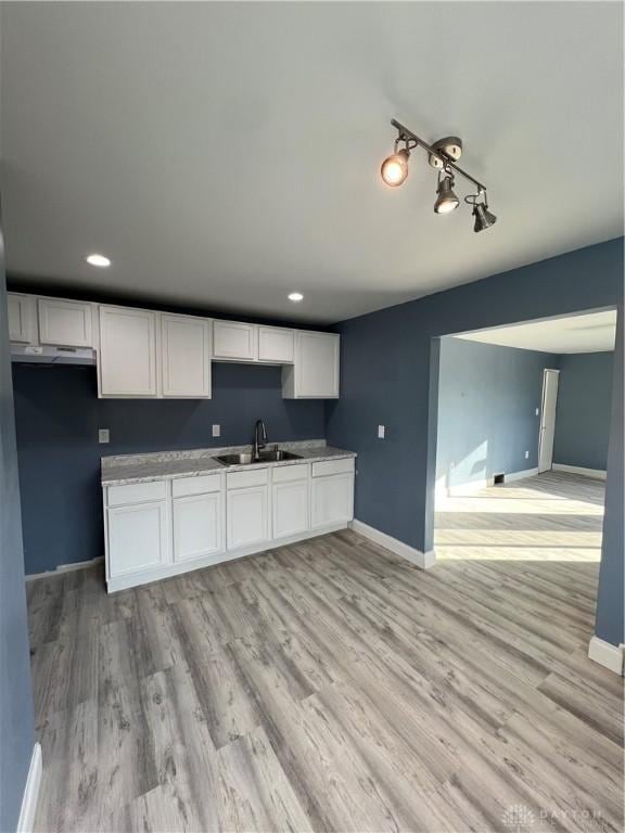 225 Victor Ave, Dayton, OH 45405 - kitchen with a sink, white cabinetry, under cabinet range hood, light wood-type flooring, and baseboards