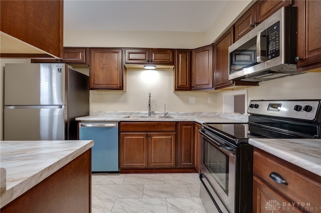 kitchen featuring stainless steel appliances, light countertops, marble finish floor, and a sink