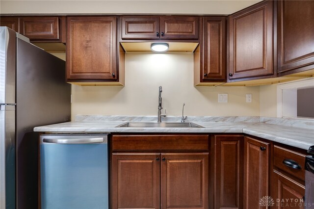kitchen featuring stainless steel appliances, light countertops, and a sink