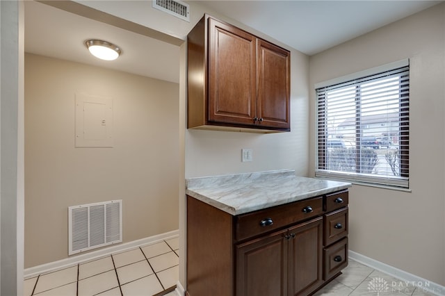kitchen with light tile patterned flooring, visible vents, light countertops, and baseboards