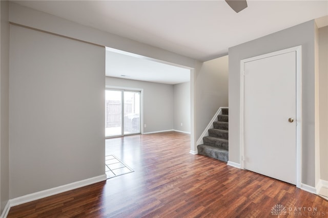 spare room with stairway, wood finished floors, and baseboards