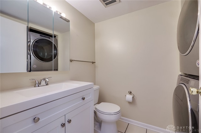bathroom with stacked washer and dryer, visible vents, toilet, tile patterned floors, and vanity