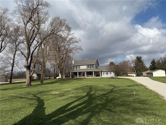 view of yard with a porch and driveway