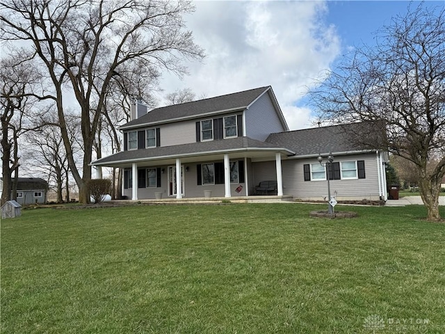 view of front of house featuring covered porch, a chimney, and a front lawn