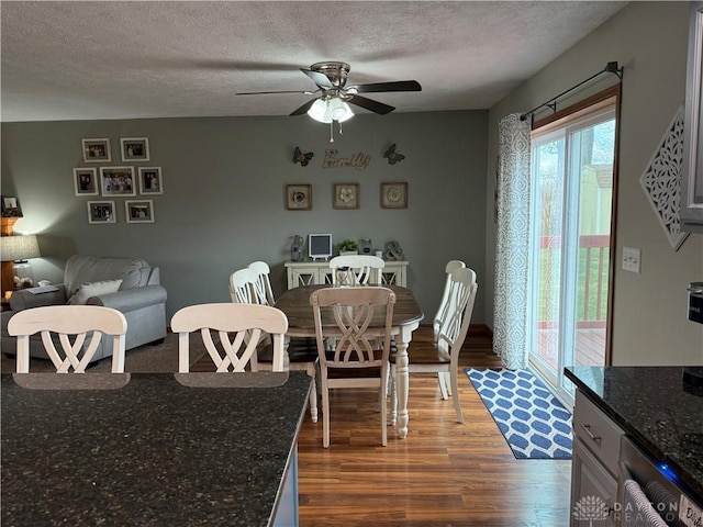 dining area featuring a textured ceiling, wood finished floors, and ceiling fan