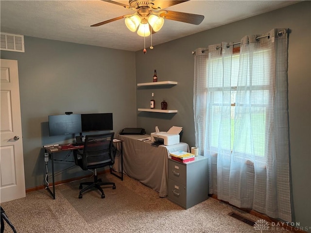 office area featuring carpet, a ceiling fan, visible vents, and a textured ceiling