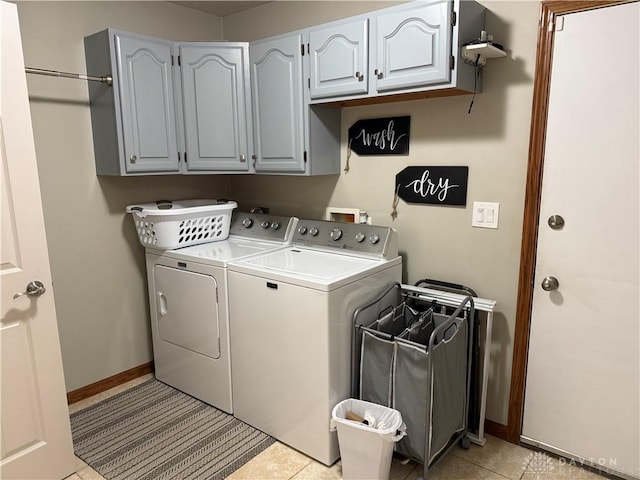 laundry area with baseboards, cabinet space, washing machine and dryer, and light tile patterned flooring