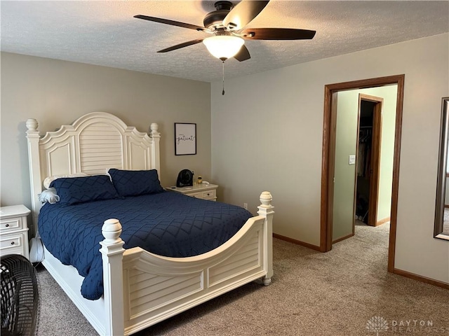 bedroom featuring baseboards, light colored carpet, a ceiling fan, and a textured ceiling
