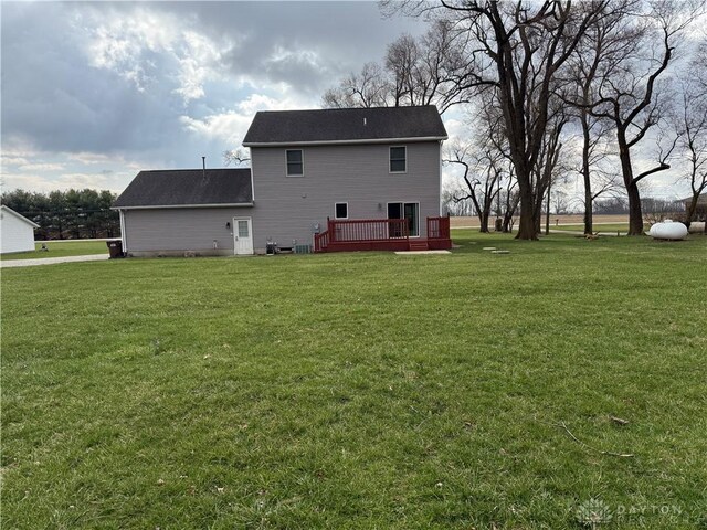 back of house with a wooden deck and a yard