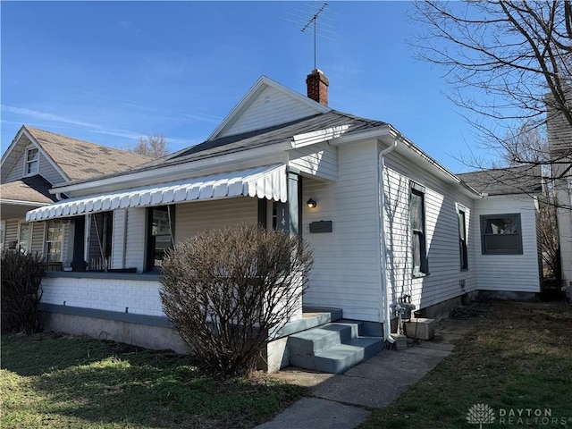 view of home's exterior with entry steps and a chimney