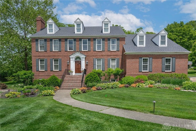 533 Lockerbie Ln, Kettering, OH 45429 - colonial house with brick siding, a front yard, and a chimney