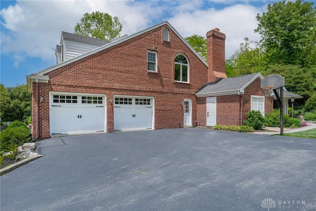 533 Lockerbie Ln, Kettering, OH 45429 - view of side of property featuring driveway, brick siding, and a chimney
