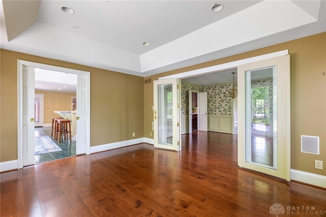 533 Lockerbie Ln, Kettering, OH 45429 - unfurnished room with a tray ceiling, wallpapered walls, wood finished floors, baseboards, and french doors