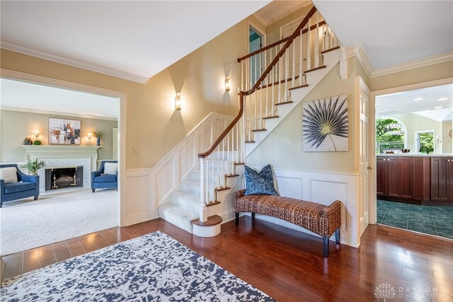 533 Lockerbie Ln, Kettering, OH 45429 - stairs featuring hardwood / wood-style flooring, a wainscoted wall, a fireplace, a decorative wall, and crown molding