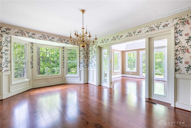 533 Lockerbie Ln, Kettering, OH 45429 - unfurnished dining area with wallpapered walls, a chandelier, a wainscoted wall, a decorative wall, and wood finished floors