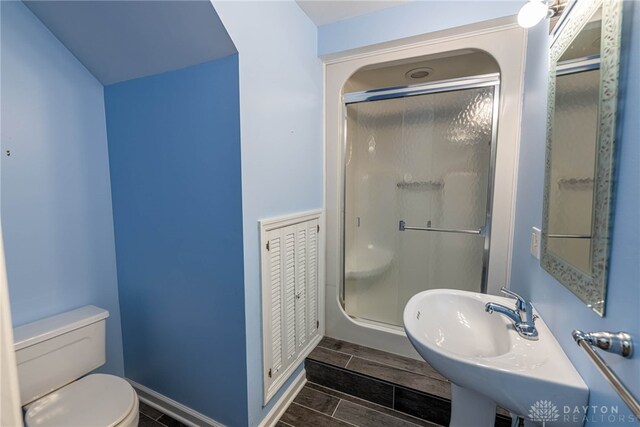 533 Lockerbie Ln, Kettering, OH 45429 - full bathroom with a stall shower, toilet, a sink, baseboards, and wood tiled floors