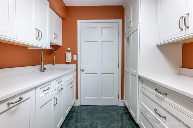 533 Lockerbie Ln, Kettering, OH 45429 - kitchen featuring a sink, white cabinetry, light countertops, and dark tile patterned floors