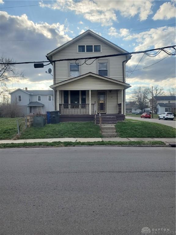 view of front facade featuring covered porch and a front yard