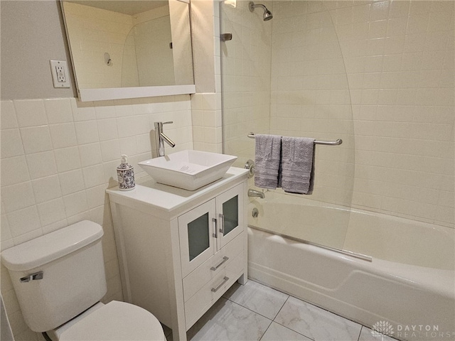 full bath featuring tile walls, vanity, shower / bathing tub combination, toilet, and marble finish floor
